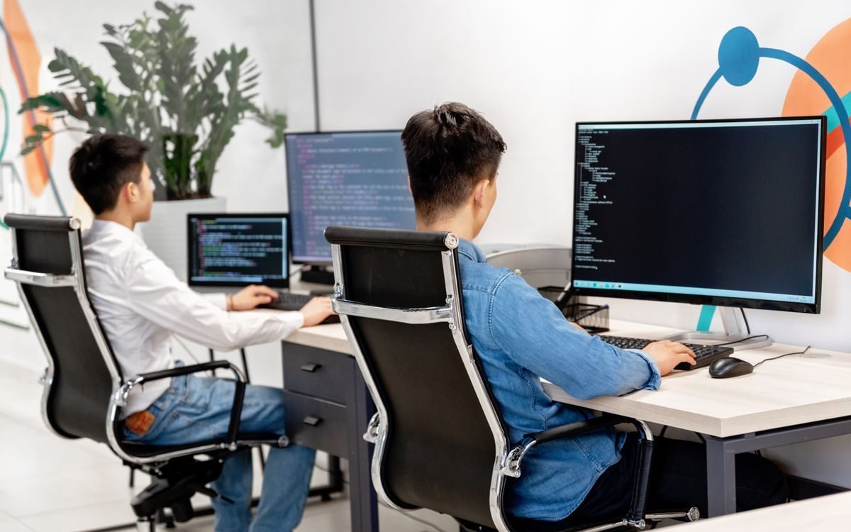 Colleagues working together at computers in an open-plan office